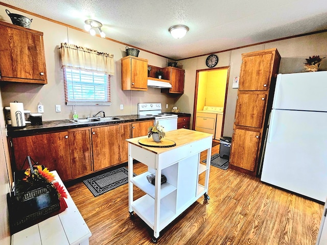 kitchen featuring ornamental molding, a textured ceiling, white appliances, washer and dryer, and light hardwood / wood-style flooring