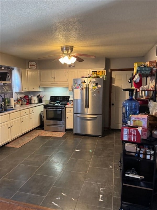 kitchen featuring light countertops, white cabinets, a ceiling fan, and stainless steel appliances