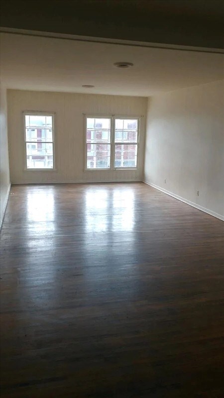 115, 117 N Rollins St, Macon, MO 63552 - empty room with baseboards, a healthy amount of sunlight, and dark wood finished floors