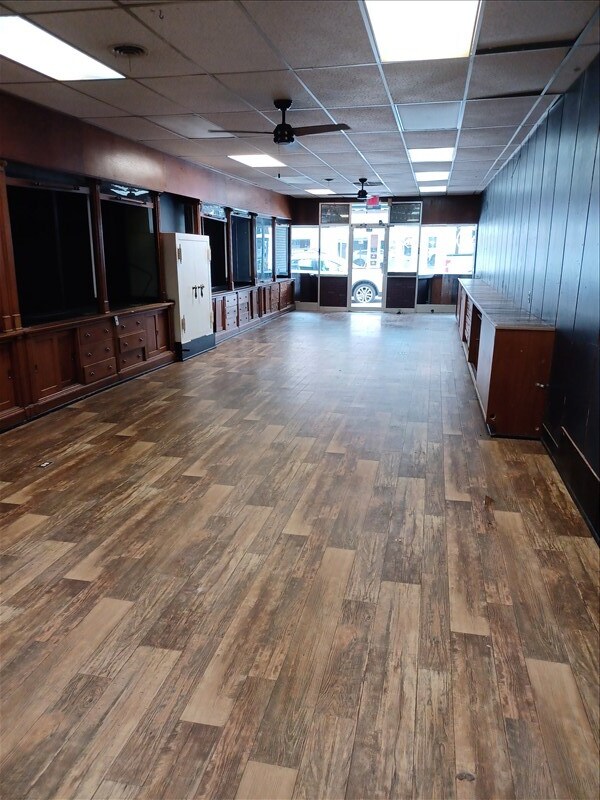 115, 117 N Rollins St, Macon, MO 63552 - interior space featuring visible vents, a drop ceiling, and dark wood-style floors