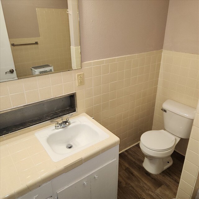 115, 117 N Rollins St, Macon, MO 63552 - bathroom featuring toilet, vanity, wood finished floors, and tile walls