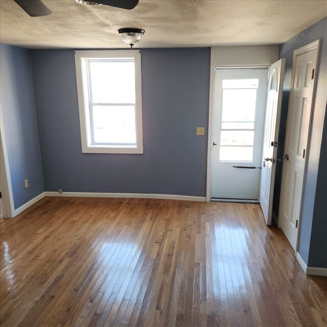 115, 117 N Rollins St, Macon, MO 63552 - interior space featuring wood-type flooring, baseboards, and a textured ceiling