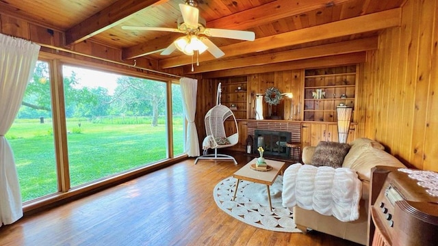 64234 Hwy 6, Green Castle, MO 63544 - living area featuring a wooden ceiling with exposed beams, wood walls, wood finished floors, ceiling fan, and a fireplace