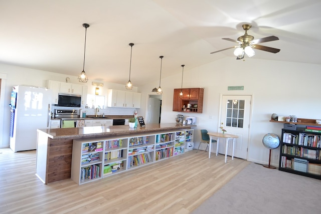 kitchen with ceiling fan, a sink, light wood-style floors, stainless steel appliances, and a peninsula