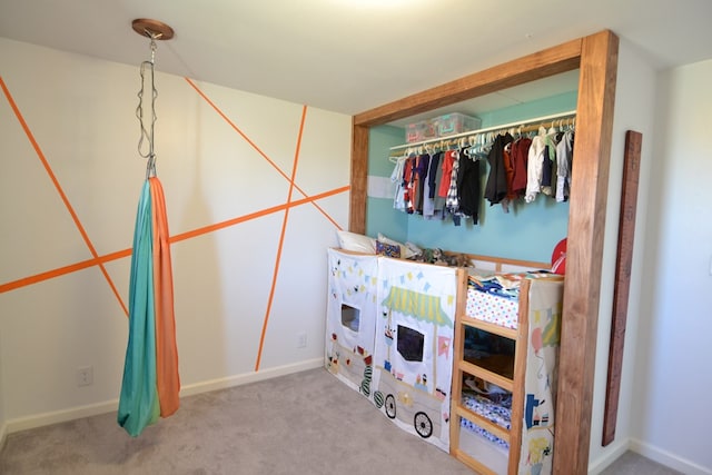 carpeted bedroom featuring baseboards and a closet