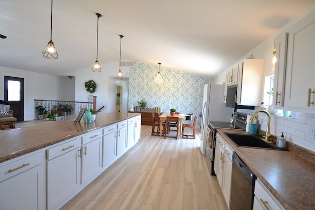 kitchen with electric range, a sink, white cabinetry, wallpapered walls, and dishwashing machine