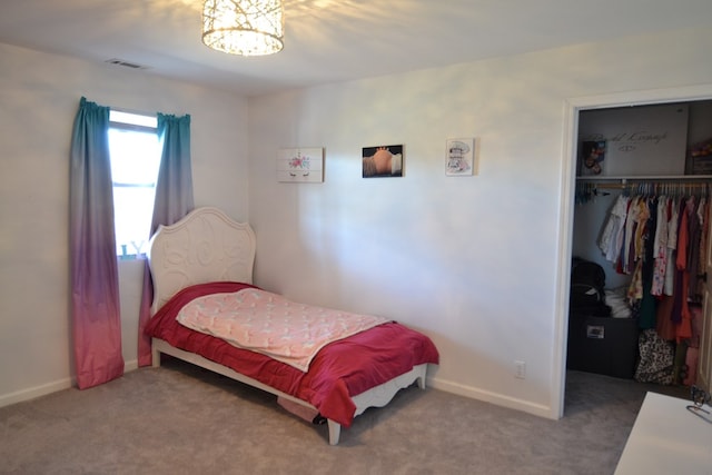 carpeted bedroom featuring an inviting chandelier, a walk in closet, baseboards, visible vents, and a closet