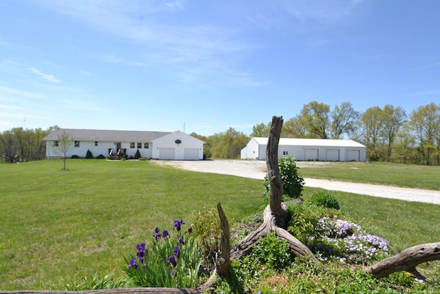 view of front of home with an outdoor structure, a front yard, and dirt driveway