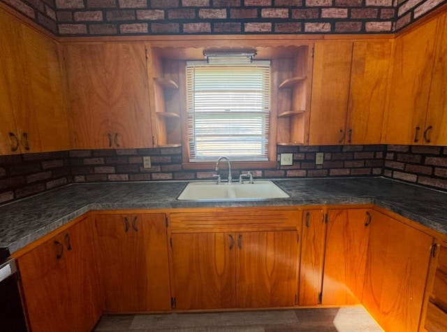 kitchen with dark countertops, brown cabinets, open shelves, and a sink