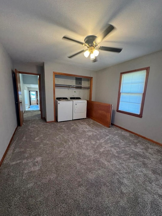 unfurnished bedroom featuring a textured ceiling, multiple windows, carpet, and washing machine and clothes dryer