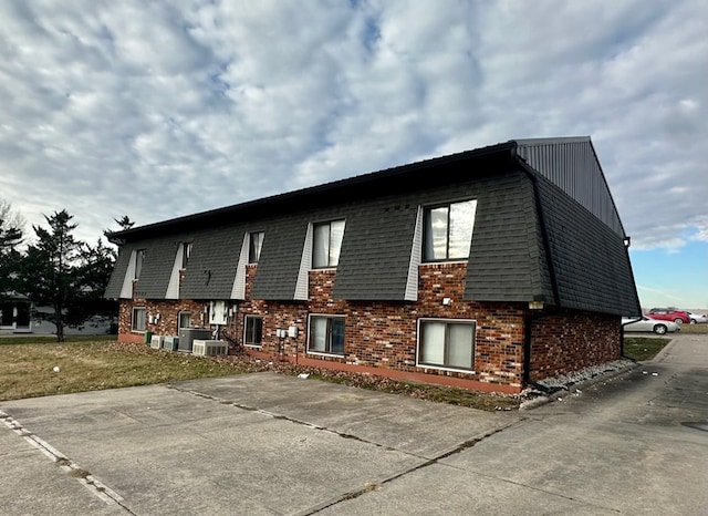 1302 Queens Ct, Kirksville, MO 63501 - view of home's exterior with central AC, brick siding, and mansard roof