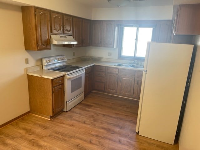 1302 Queens Ct, Kirksville, MO 63501 - kitchen featuring white appliances, under cabinet range hood, light wood finished floors, light countertops, and a sink