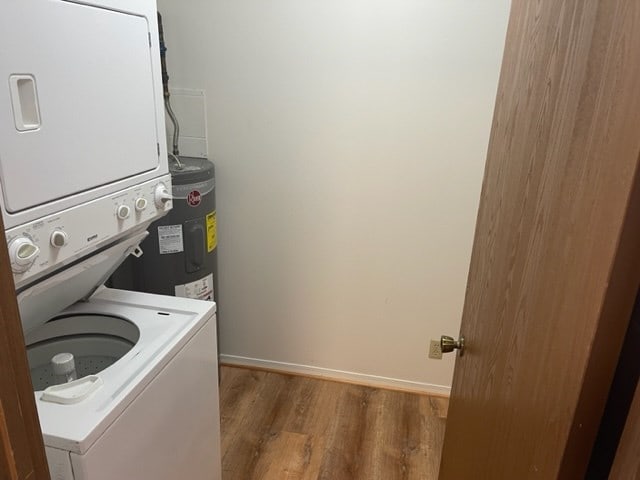 1302 Queens Ct, Kirksville, MO 63501 - laundry area with stacked washing machine and dryer, wood finished floors, baseboards, and water heater