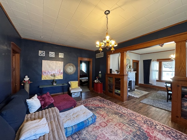 616 E Jefferson St, Kirksville, MO 63501 - living room featuring visible vents, wood finished floors, crown molding, baseboards, and a chandelier