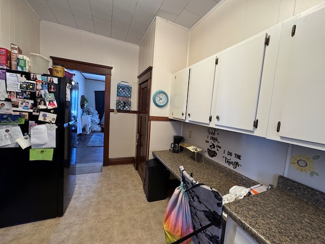 616 E Jefferson St, Kirksville, MO 63501 - kitchen with a decorative wall, white cabinetry, and freestanding refrigerator