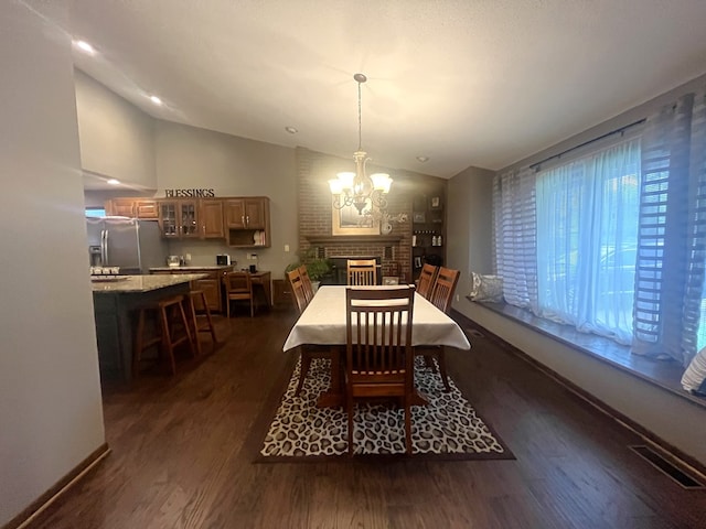 dining area featuring a notable chandelier, baseboards, lofted ceiling, dark wood-type flooring, and visible vents