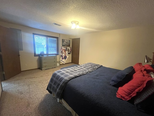 bedroom with light carpet, a textured ceiling, and visible vents