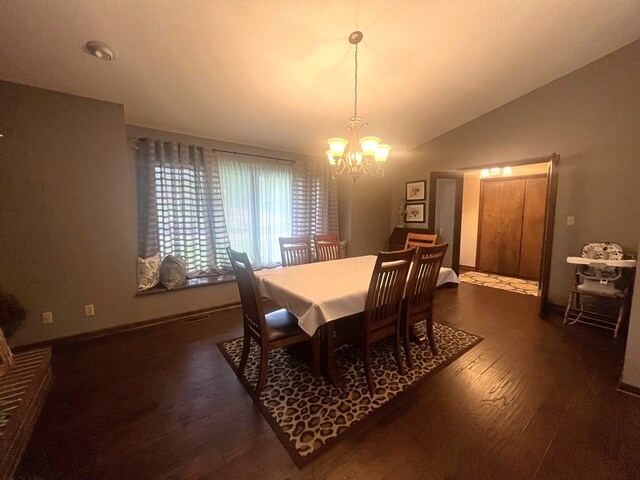 dining space with baseboards, a chandelier, wood finished floors, and lofted ceiling