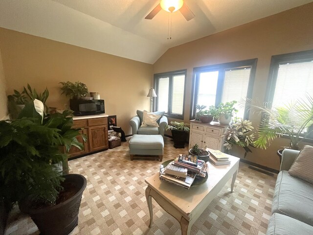 living area featuring light colored carpet, lofted ceiling, and a ceiling fan