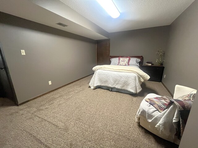 bedroom with a textured ceiling, visible vents, baseboards, and carpet floors