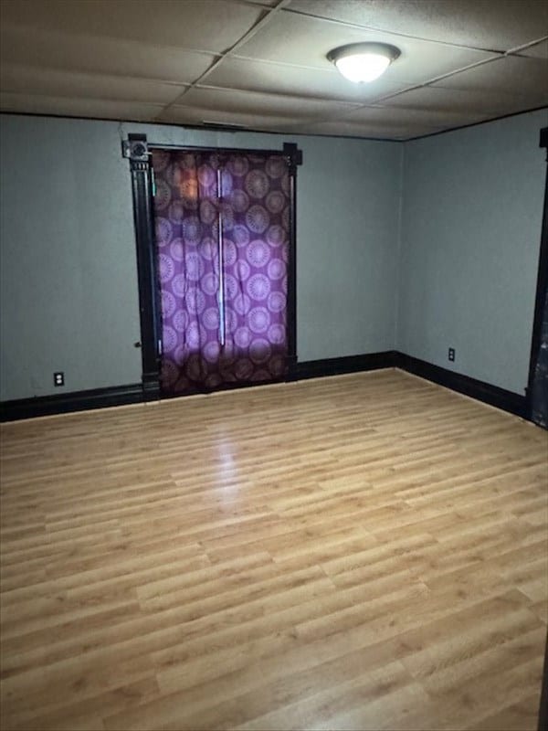 unfurnished room with light hardwood / wood-style floors and a drop ceiling