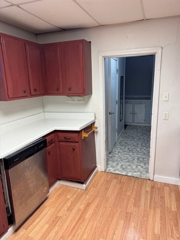 kitchen with dishwasher, a drop ceiling, and light hardwood / wood-style flooring