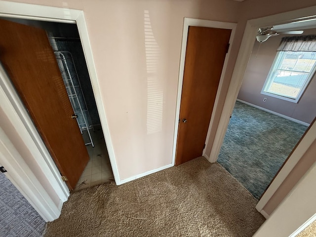 corridor featuring carpet flooring and baseboards