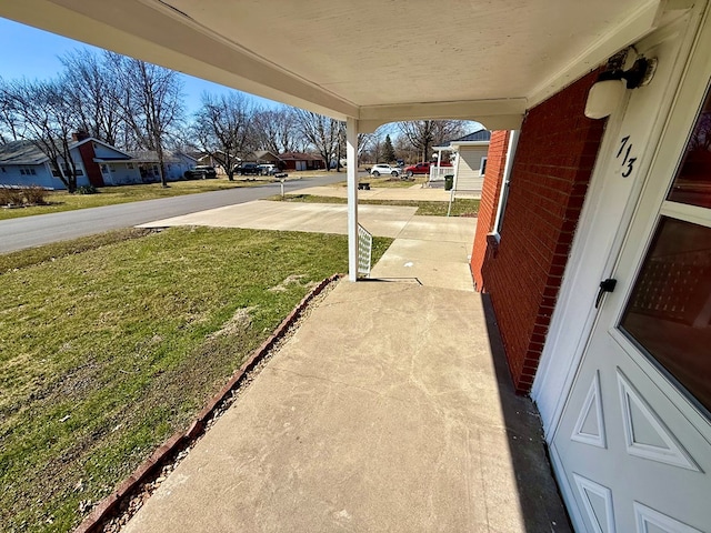 exterior space featuring a residential view, a porch, and concrete driveway