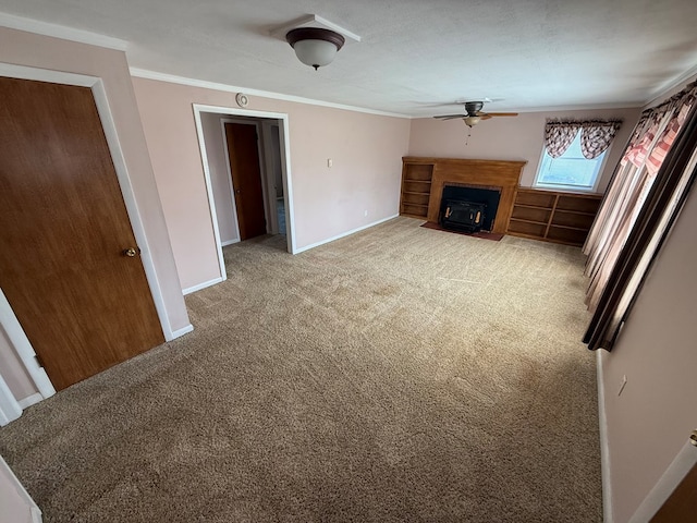 unfurnished living room with ceiling fan, baseboards, a fireplace with flush hearth, ornamental molding, and light carpet