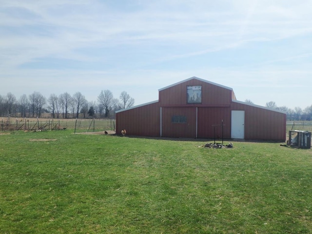 view of outbuilding featuring a lawn and a rural view