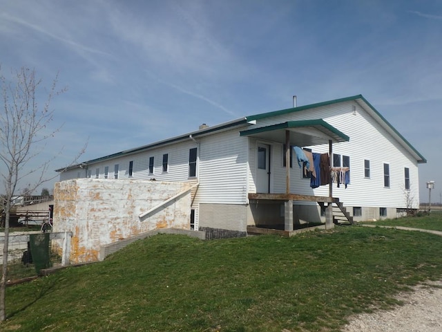 rear view of house featuring a lawn