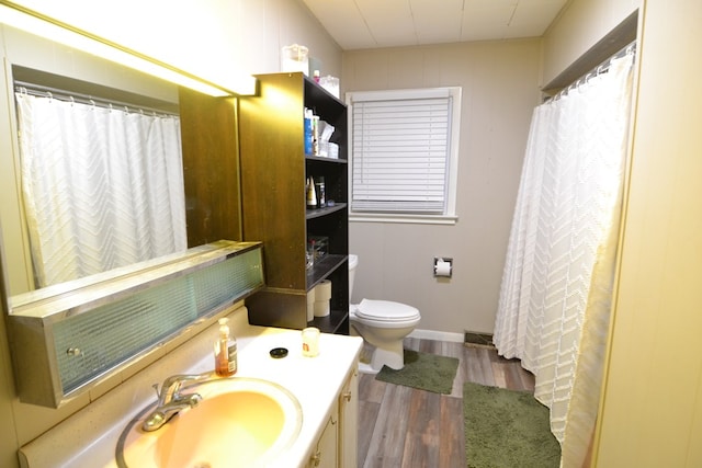 bathroom with visible vents, wood finished floors, vanity, and toilet