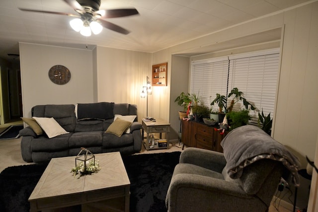 carpeted living area with a ceiling fan