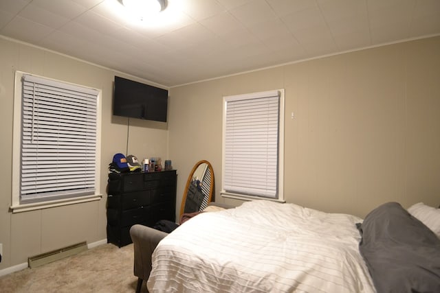 bedroom featuring baseboard heating, light colored carpet, and ornamental molding