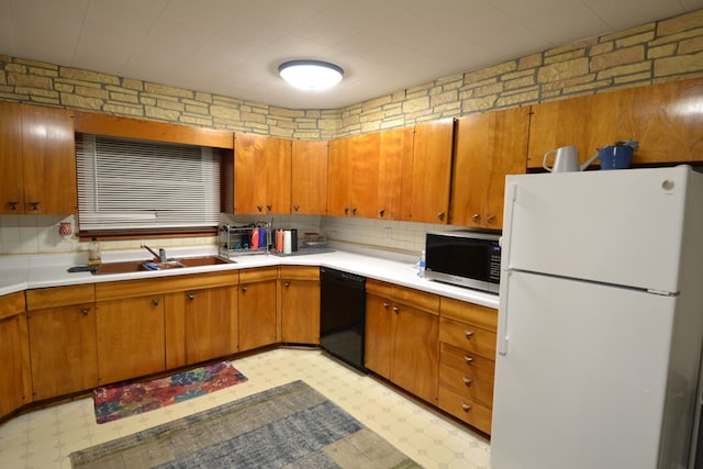 kitchen with white refrigerator, sink, and black dishwasher