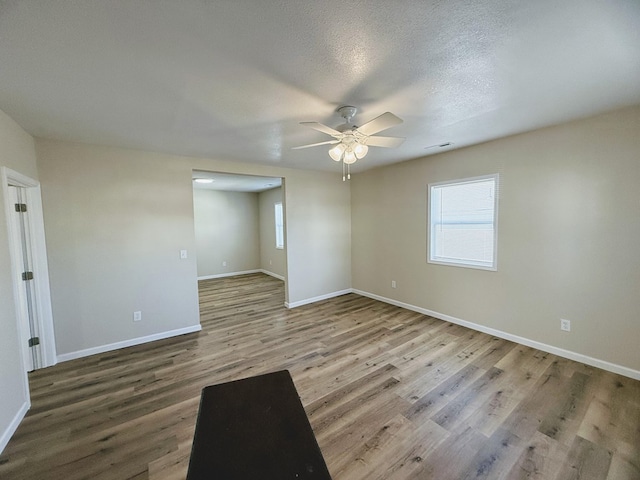 empty room featuring hardwood / wood-style flooring, ceiling fan, and a textured ceiling