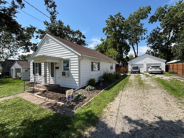 712 W Shelby, Kirksville, MO 63501 - view of front of home with a detached garage, an outdoor structure, cooling unit, and roof with shingles