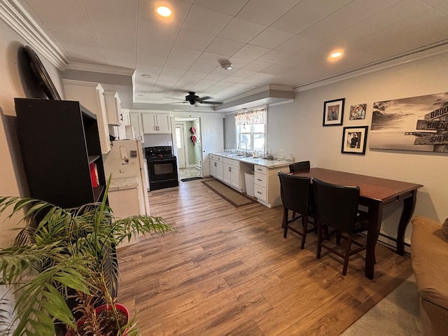 712 W Shelby, Kirksville, MO 63501 - kitchen featuring black electric range oven, ornamental molding, white cabinets, light wood finished floors, and light countertops