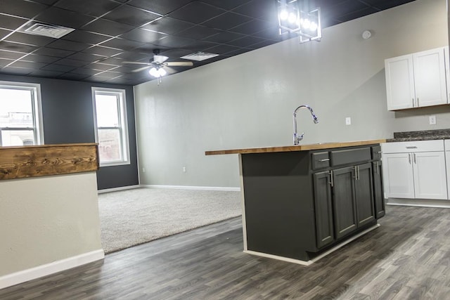 kitchen with a paneled ceiling, white cabinetry, ceiling fan, and dark wood-type flooring