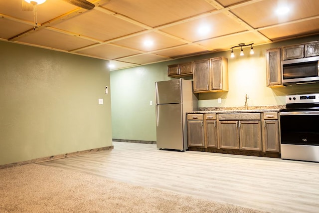 kitchen featuring sink, light colored carpet, and stainless steel appliances