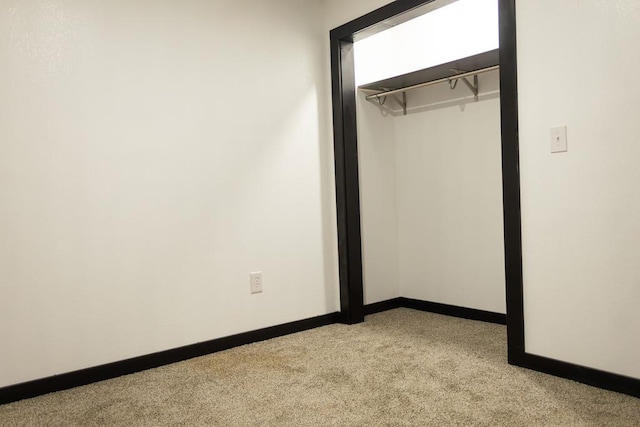 unfurnished bedroom with light carpet and a closet