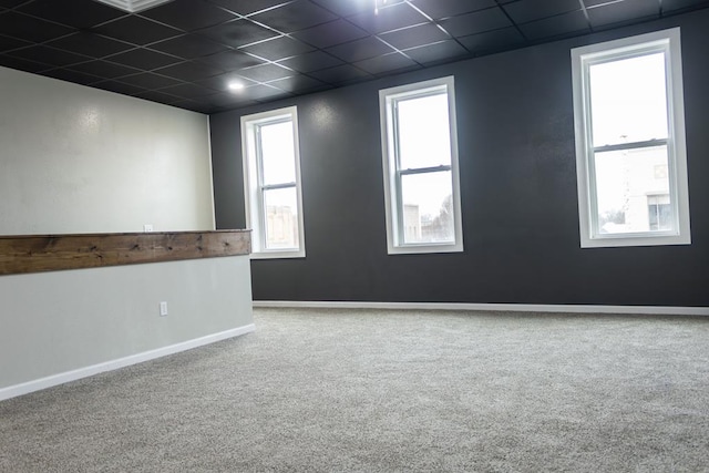 empty room with a drop ceiling and carpet floors