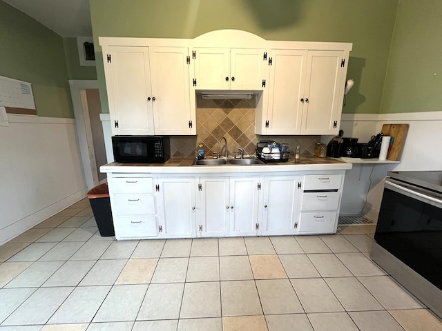 432 Woodrow, Chillicothe, MO 64601 - kitchen with white cabinetry, stainless steel electric stove, a sink, light tile patterned flooring, and black microwave