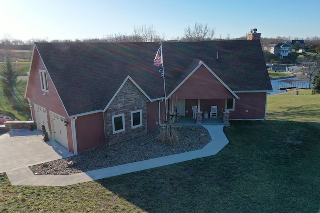 view of front of property with a porch, a garage, and a front lawn