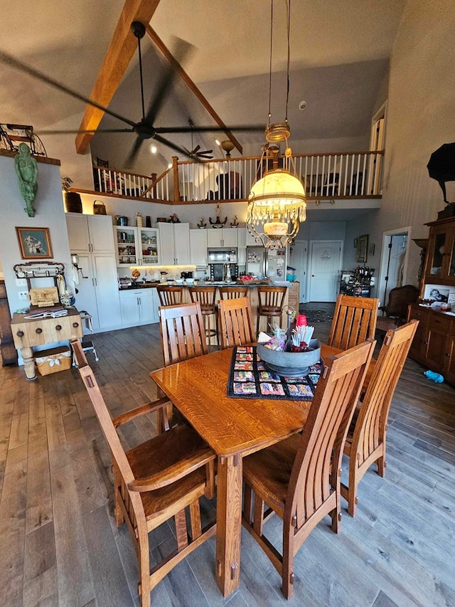 dining area featuring beamed ceiling, ceiling fan with notable chandelier, high vaulted ceiling, and dark wood-type flooring