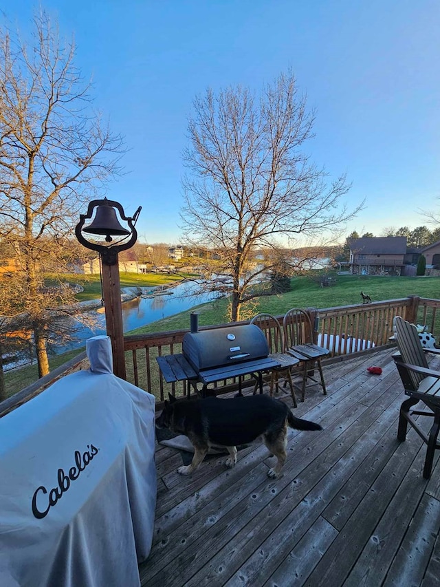 wooden terrace featuring a yard, a water view, and area for grilling