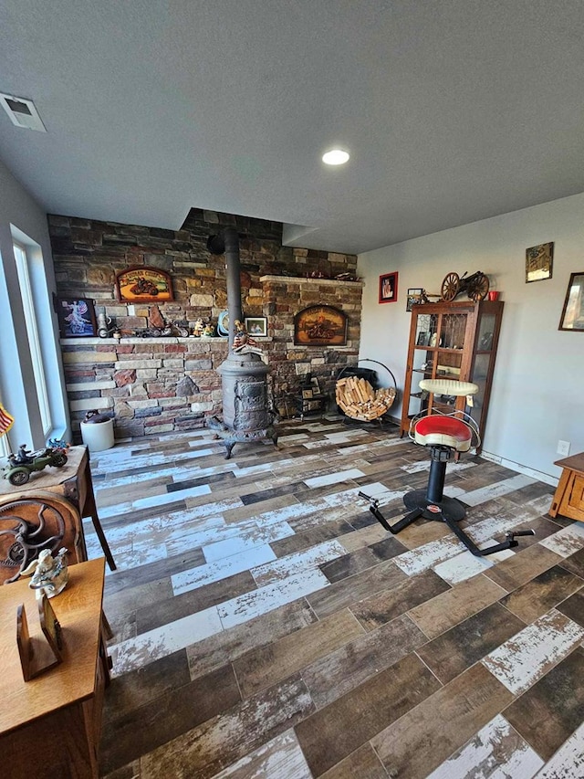 living room featuring a wood stove and a textured ceiling