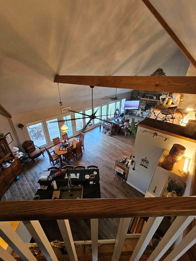 unfurnished living room featuring ceiling fan, dark hardwood / wood-style flooring, high vaulted ceiling, and a healthy amount of sunlight