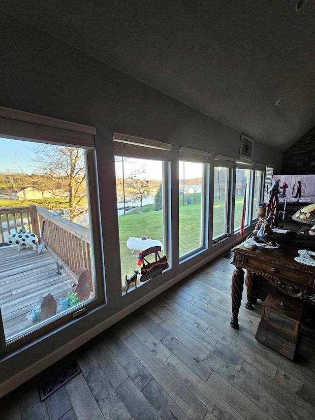 sunroom / solarium featuring a water view and lofted ceiling