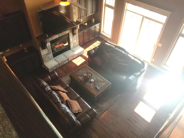 living room with a stone fireplace and hardwood / wood-style floors